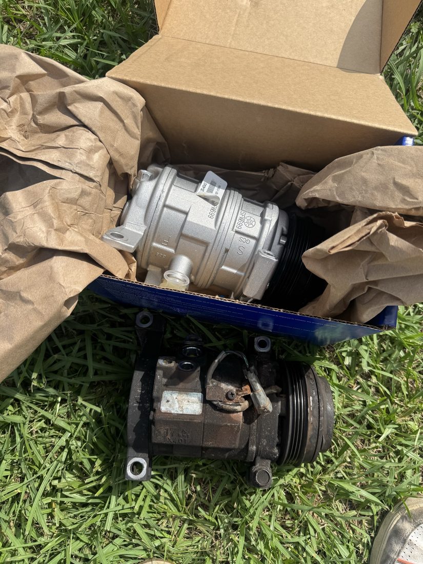 New A/C compressor next to a dirty old compressor